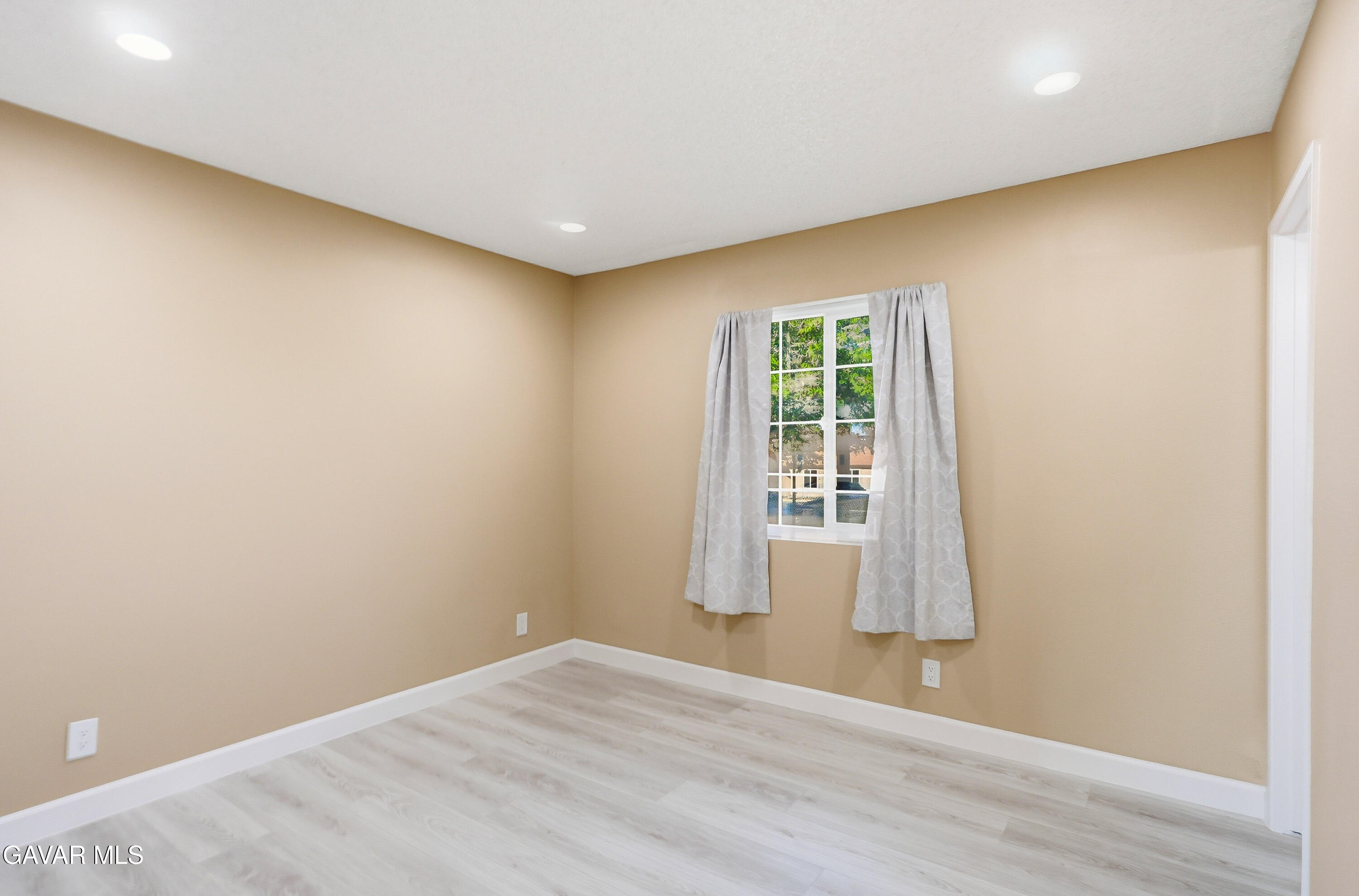 3340 West Roxbury Street Rosamond, CA 93560 - Photo 14 of 20 an empty room with wooden floor and windows