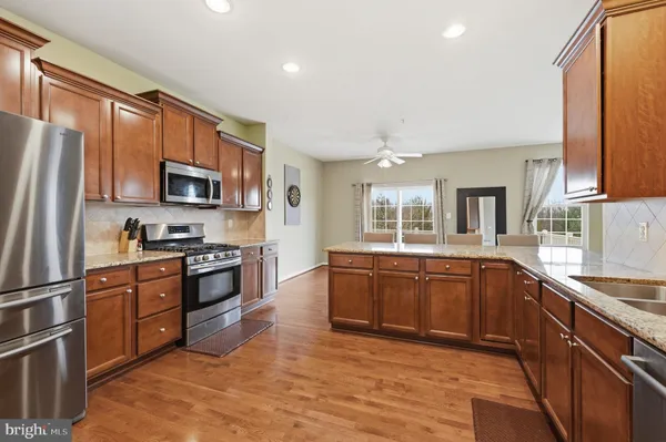 a large kitchen with stainless steel appliances granite countertop a stove sink and refrigerator
