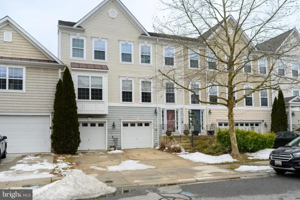 a view of a white house with a large tree