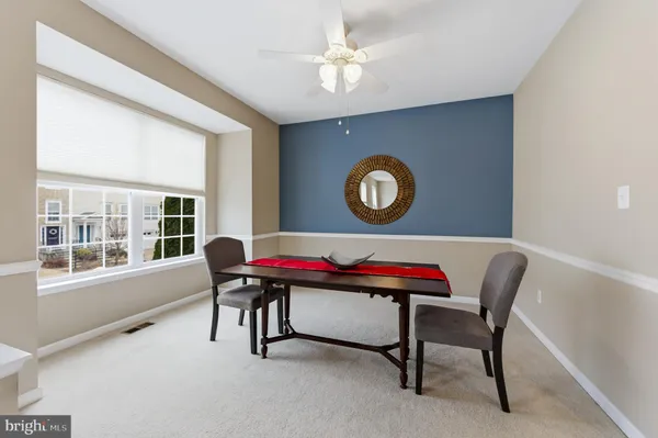 a living room with a table chair and a window