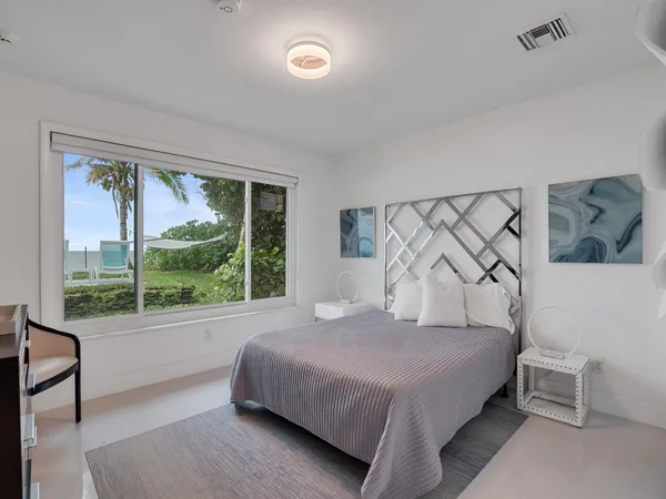 a bedroom with a bed and a lamp on dresser