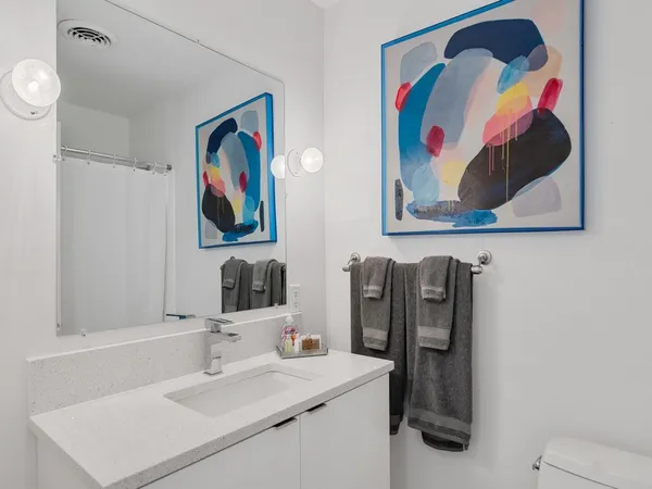 a bathroom with a sink a toilet and shower