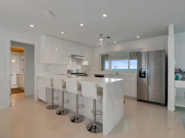 a kitchen with white cabinets and refrigerator