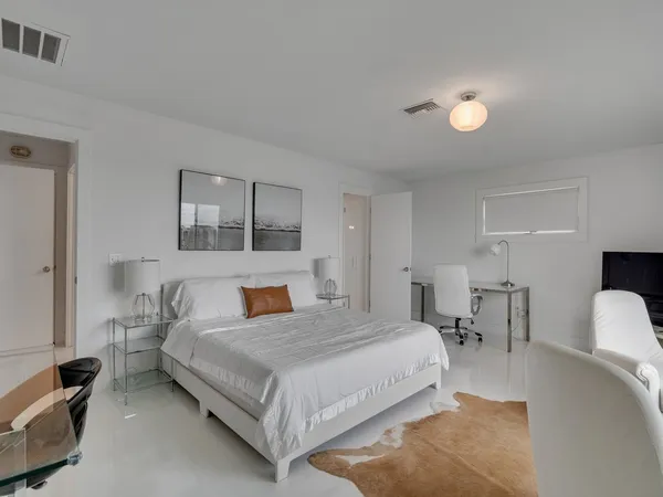 a bedroom with a bed and large windows