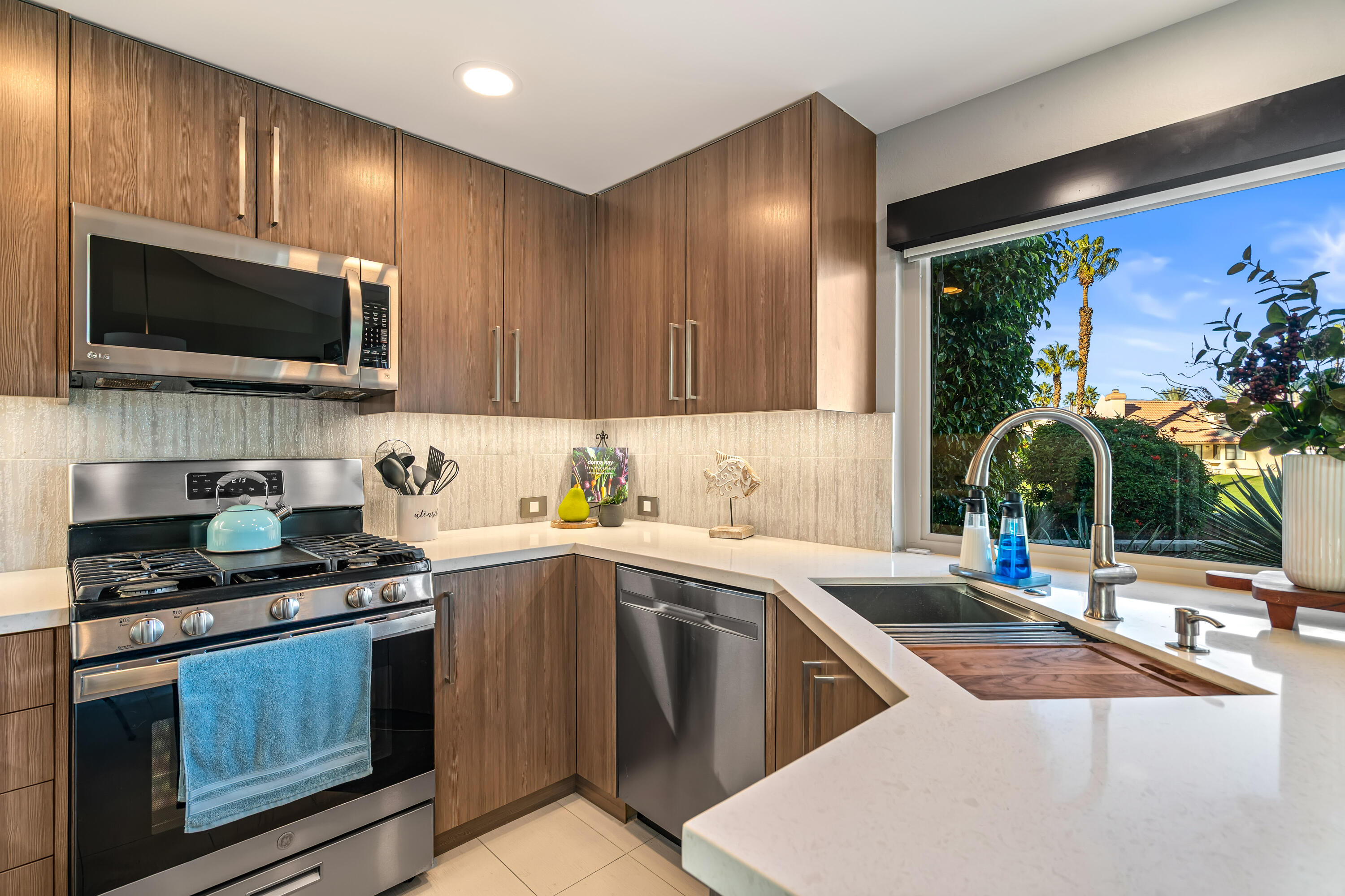 76632 Morocco Road Palm Desert, CA 92211 - Photo 10 of 38 a kitchen with stainless steel appliances a stove sink microwave and cabinets