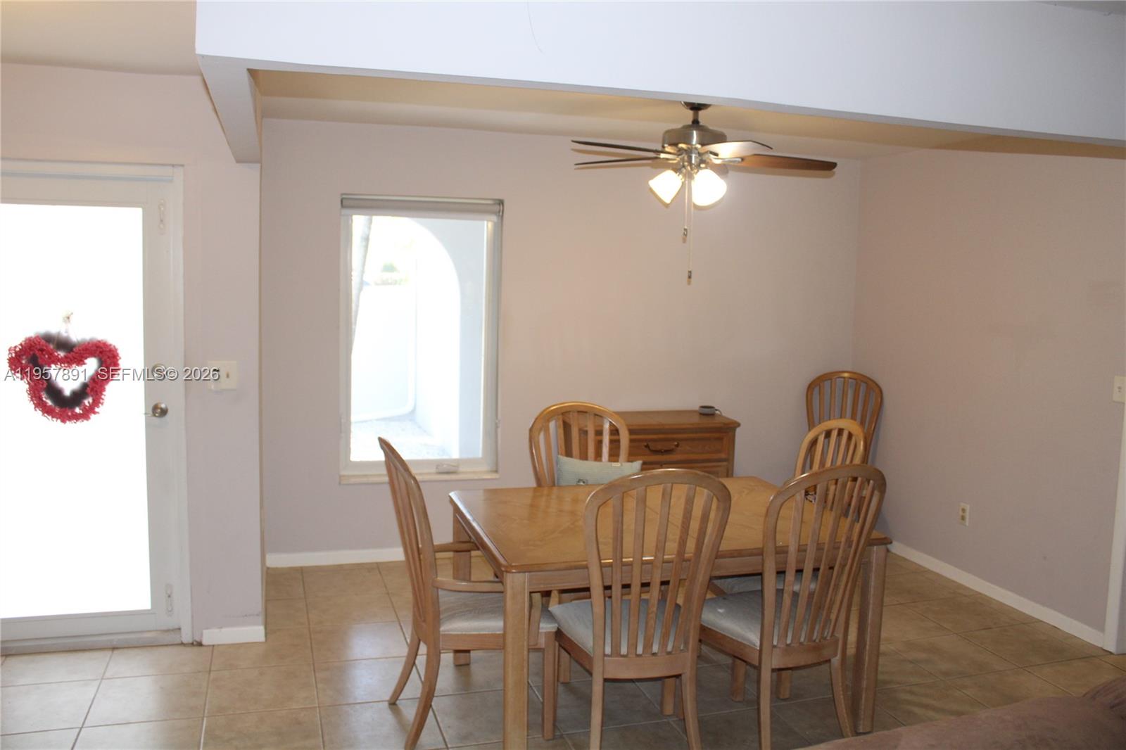 12965 Southwest 76th Terrace Miami, FL 33183 - Photo 17 of 29 a view of a dining room with furniture and chandelier fan