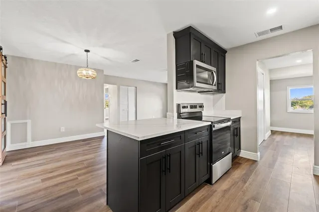 a kitchen with stainless steel appliances granite countertop a sink stove and wooden floor