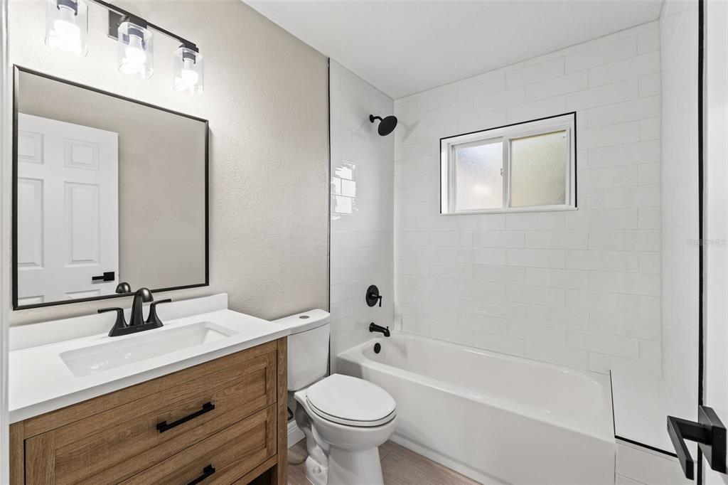 1173 Cobblestone Drive Spring Hill, FL 34606 - Photo 26 of 39 a bathroom with a double vanity sink toilet mirror and bathtub