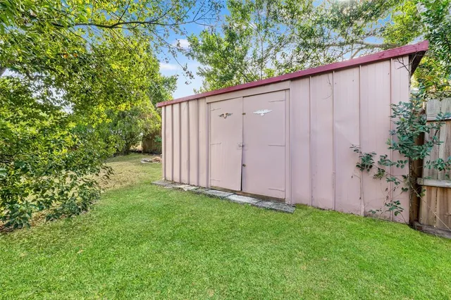 a view of a backyard with potted plants and wooden fence