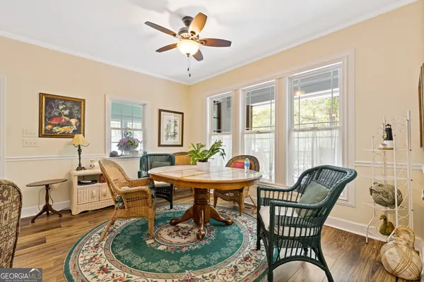 a dining room with furniture a rug a fireplace and a chandelier