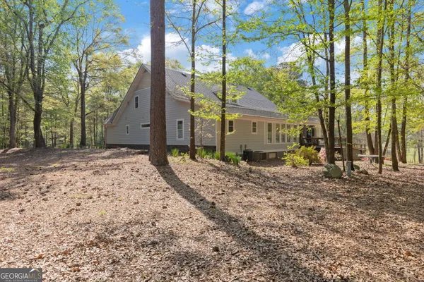 a front view of a house with a yard and large tree