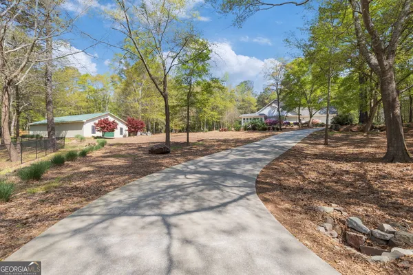 a view of a house with a yard and covered with trees