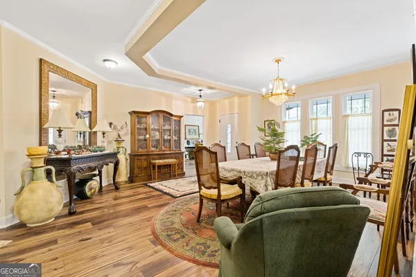 a living room with furniture a chandelier and kitchen view