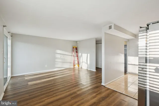 a view of empty room with wooden floor