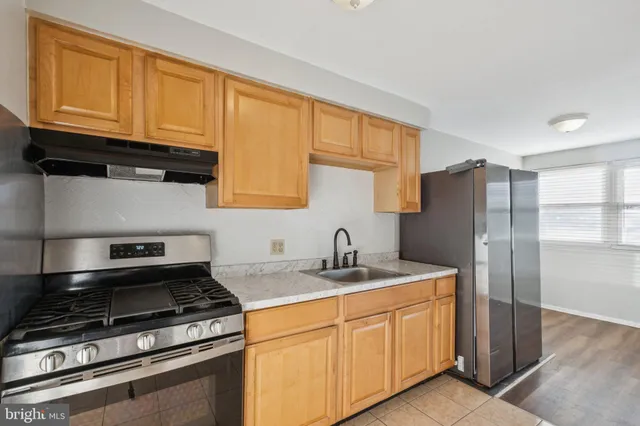 a kitchen with stainless steel appliances granite countertop a refrigerator stove and sink