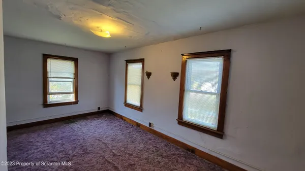 an empty room with windows and closet