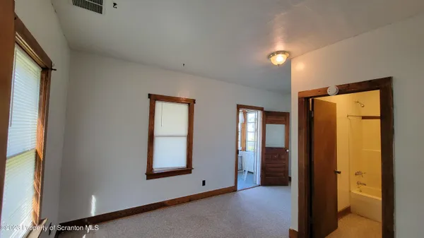 a view of an empty room with glass door and balcony