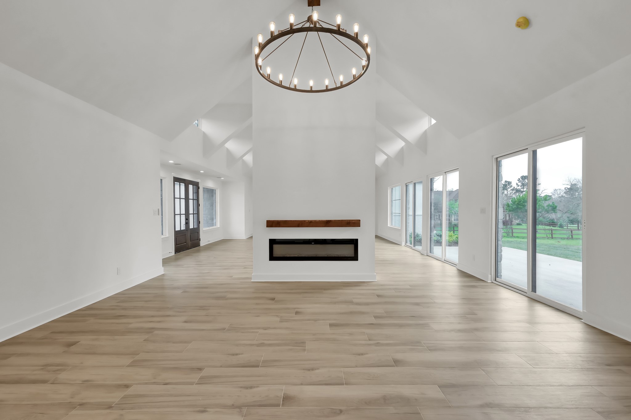 14742 Turquoise Trail Willis, TX 77378 - Photo 12 of 48 Expansive dining room showcasing architectural ceiling details, abundant natural light, and large sliding doors leading to the outdoor living space.