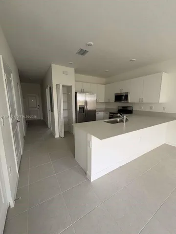 a kitchen with stainless steel appliances a refrigerator and a stove top oven