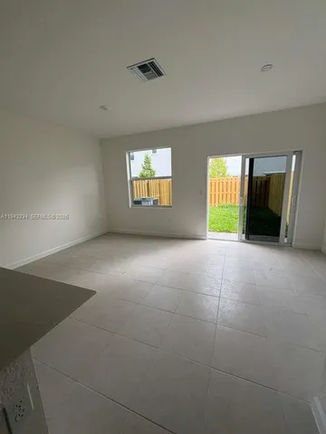 an empty room with windows and fireplace