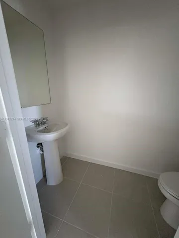 a white bathroom with sink and toilet