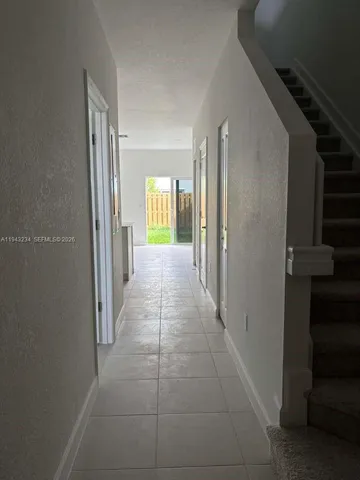 a view of a hallway with windows and a bathroom