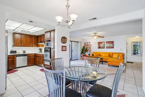 a kitchen with stainless steel appliances kitchen island granite countertop a stove a sink a dining table and chairs