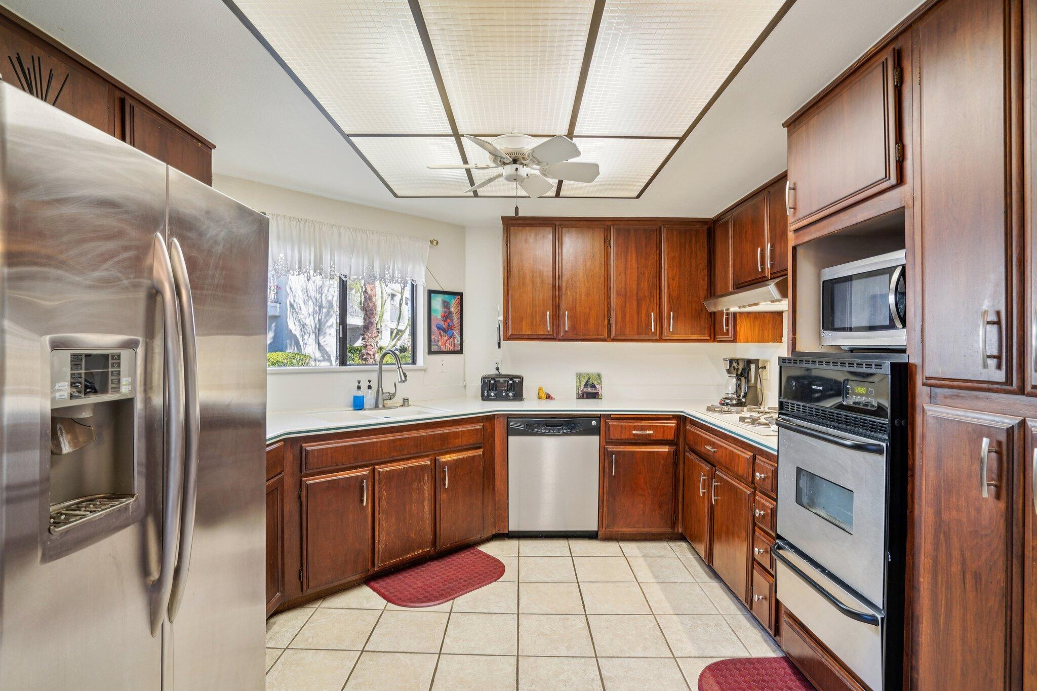 3155 Ramon Road, Unit 311 Palm Springs, CA 92264 - Photo 6 of 29 a kitchen with stainless steel appliances granite countertop a sink a stove a refrigerator cabinets and chairs