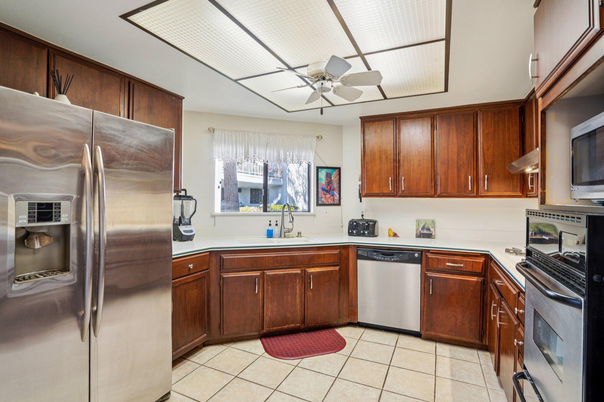 3155 Ramon Road, Unit 311 Palm Springs, CA 92264 - Photo 8 of 29 a kitchen with stainless steel appliances granite countertop a sink a stove a refrigerator cabinets and a dining table