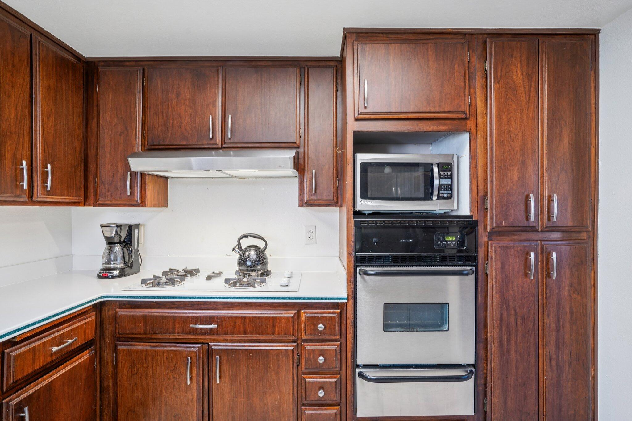 3155 Ramon Road, Unit 311 Palm Springs, CA 92264 - Photo 10 of 29 a kitchen with granite countertop wooden cabinets and stainless steel appliances