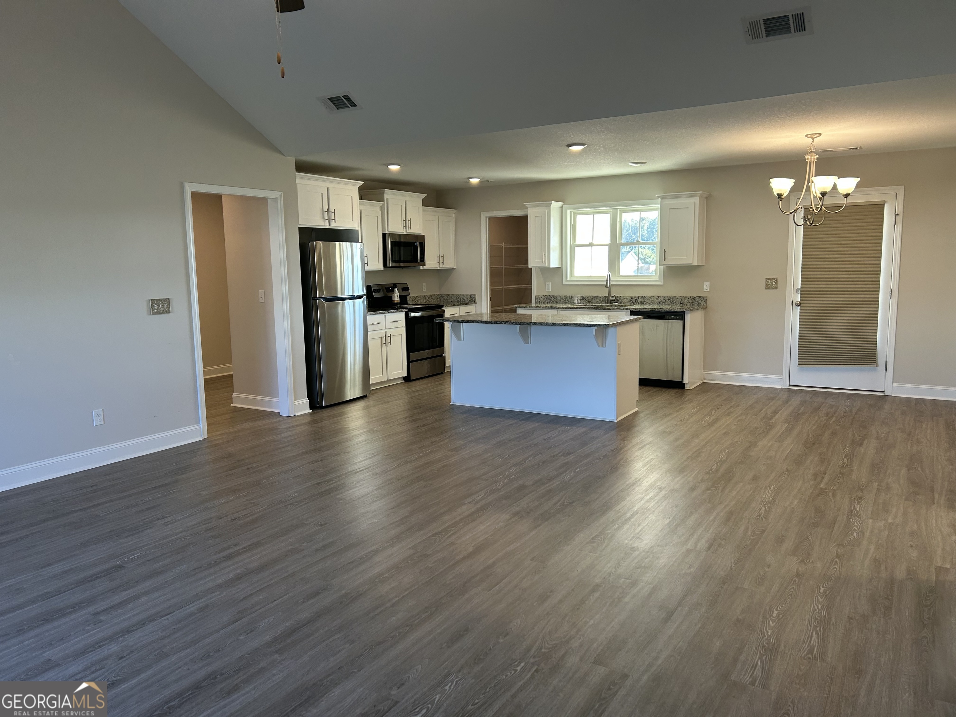 106 Old Barn Road Statesboro, GA 30458 - Photo 13 of 59 a large kitchen with stainless steel appliances kitchen island wooden floors and granite counter top