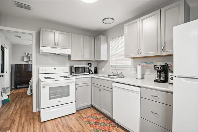 a kitchen with white cabinets sink and white appliances