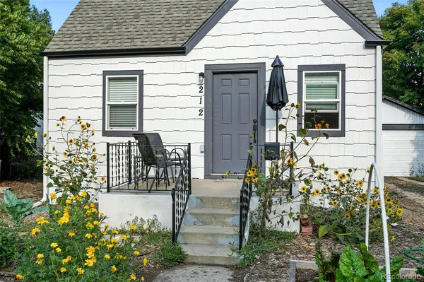 a front view of a house with outdoor seating and plants