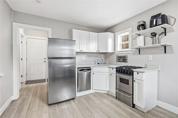 a kitchen with a refrigerator stove and wooden floor