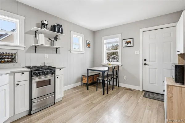 a kitchen with cabinets and wooden floor