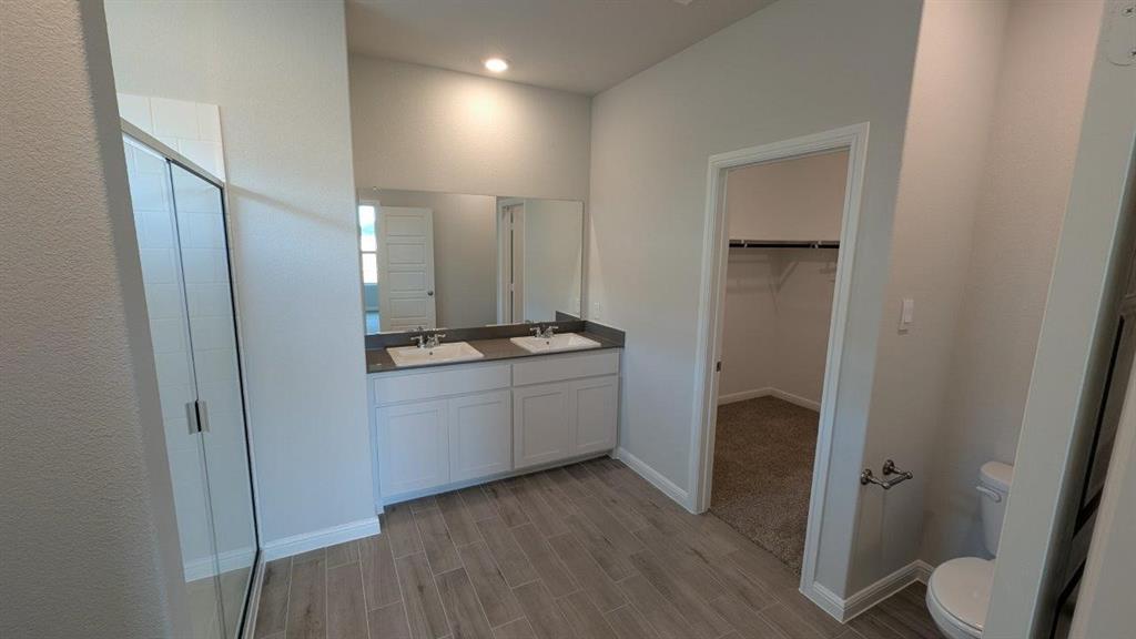 1021 Traction Trail Cleburne, TX 76031 - Photo 6 of 16 a bathroom with a granite countertop sink and a mirror