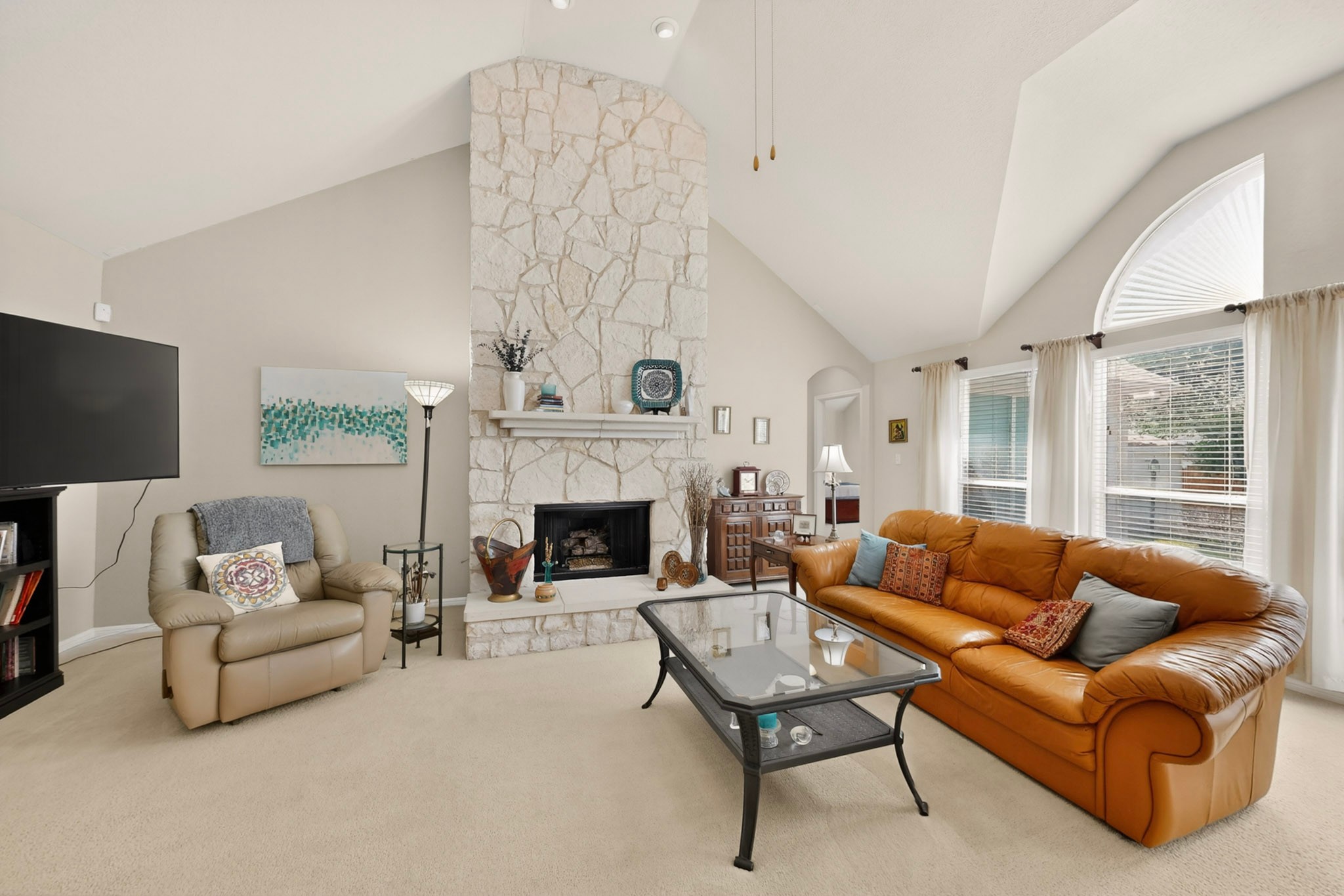 905 Victoria Ridge Drive Pflugerville, TX 78660 - Photo 5 of 32 A striking stone fireplace rises to meet the vaulted ceilings, defining this inviting living area.