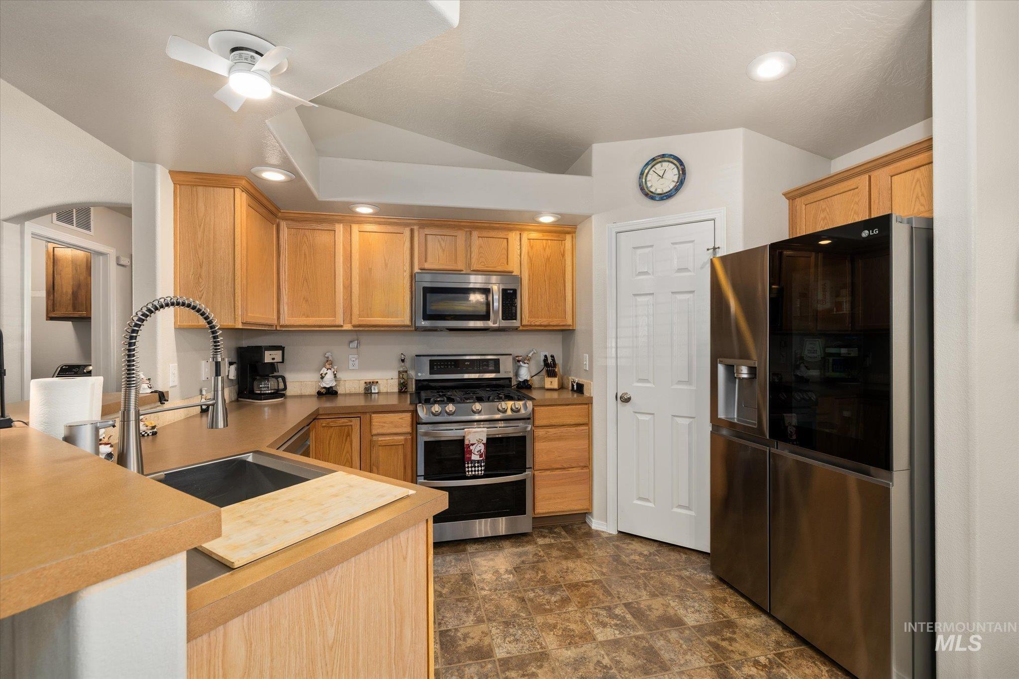 5401 Barkley Way Caldwell, ID 83607 - Photo 20 of 35 Kitchen featuring wood cabinetry, stainless steel appliances, a modern pull-down faucet, recessed lighting, and resilient flooring