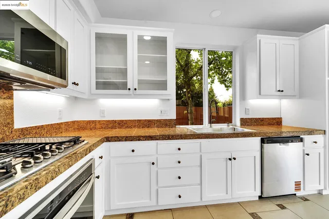 a kitchen with granite countertop a stove a sink and a microwave