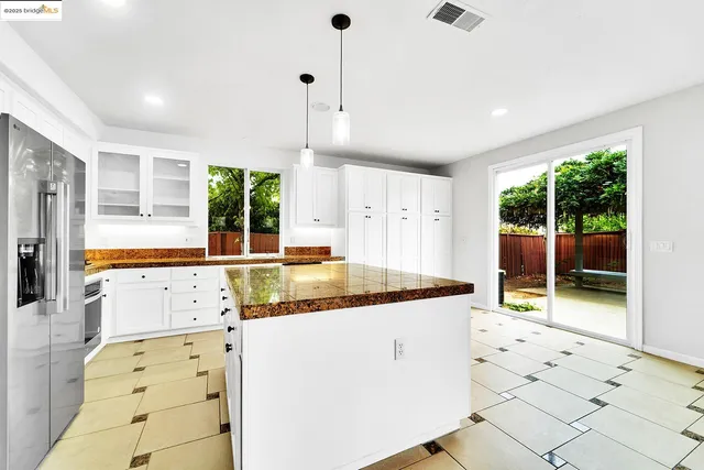 a kitchen with stainless steel appliances kitchen island granite countertop a sink and cabinets