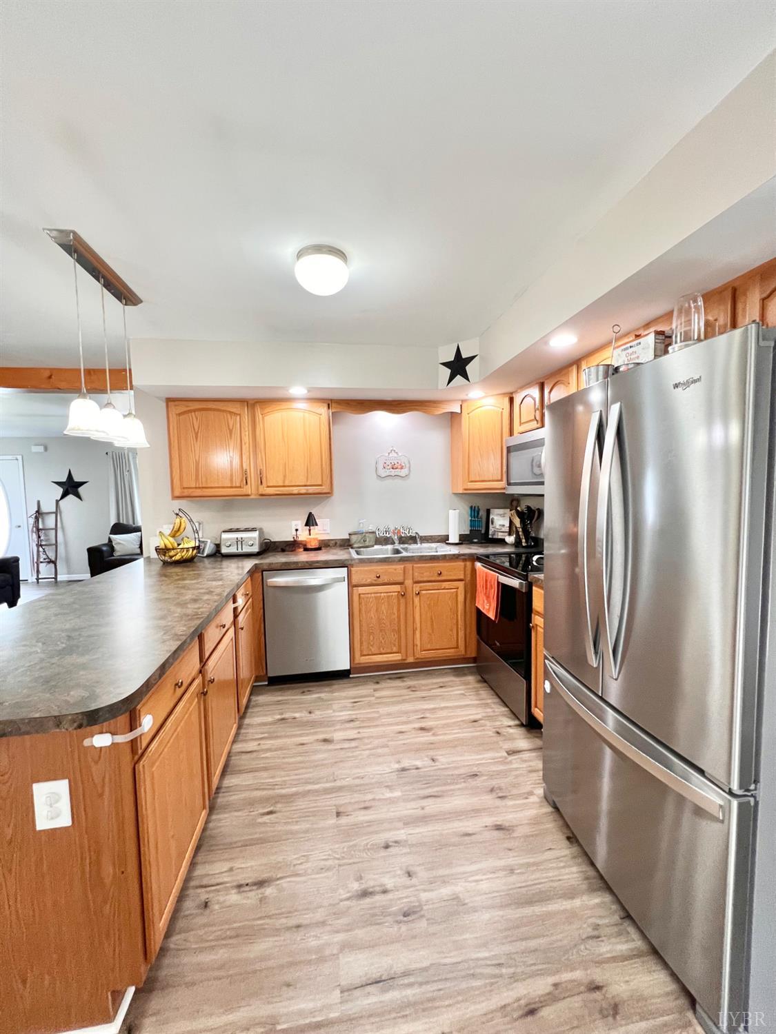 102 Fawn Court Amherst, VA 24521 - Photo 16 of 64 a large kitchen with stainless steel appliances granite countertop a refrigerator a sink dishwasher and a stove with wooden floor