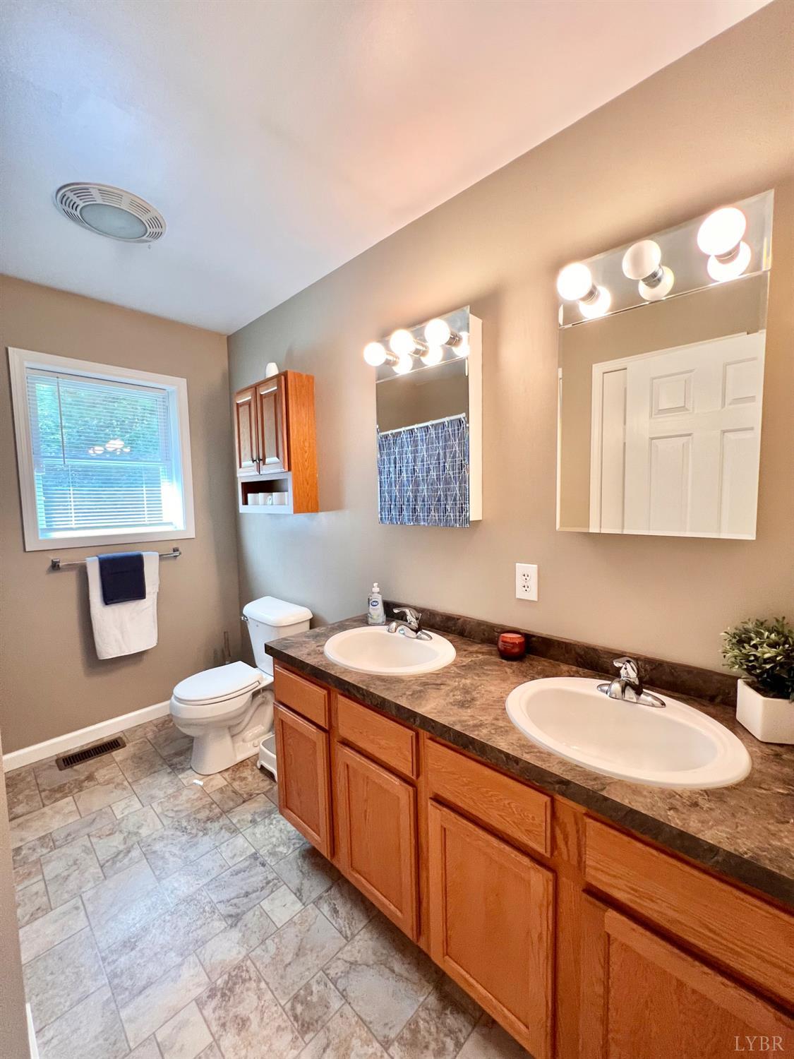 102 Fawn Court Amherst, VA 24521 - Photo 32 of 64 a bathroom with a granite countertop double vanity sink a mirror and a bathtub