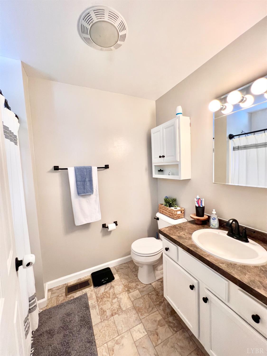 102 Fawn Court Amherst, VA 24521 - Photo 6 of 64 a bathroom with a granite countertop sink toilet a mirror and vanity