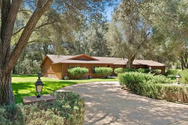 a front view of a house with a yard and shrubs