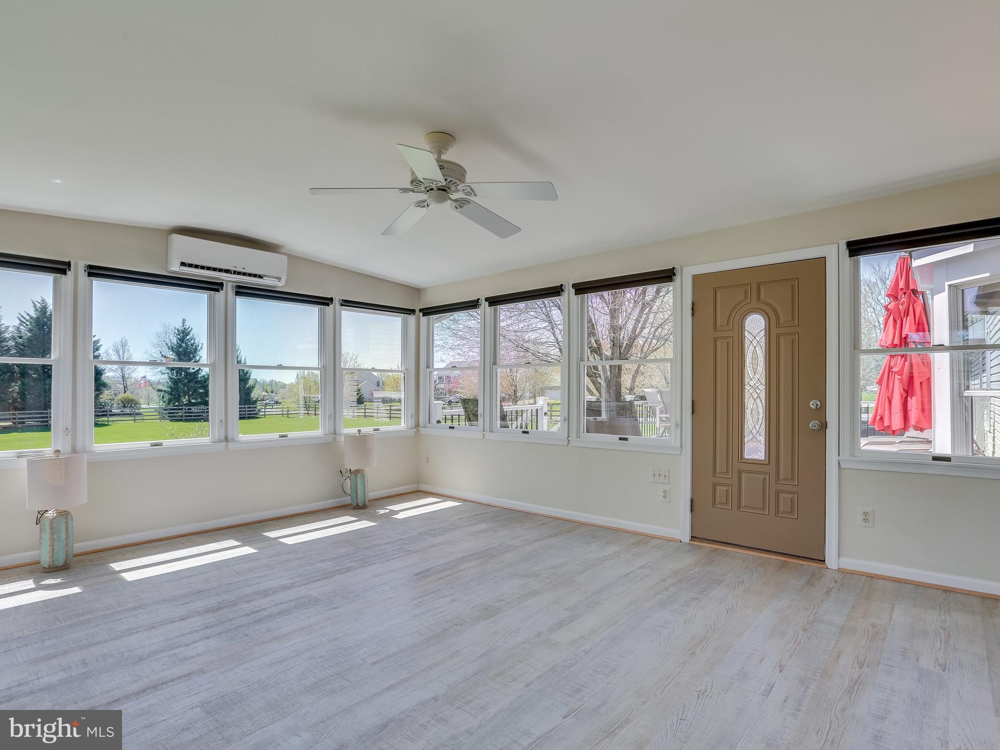 16910 Hoskinson Road Poolesville, MD 20837 - Photo 12 of 30 an empty room with wooden floor and windows