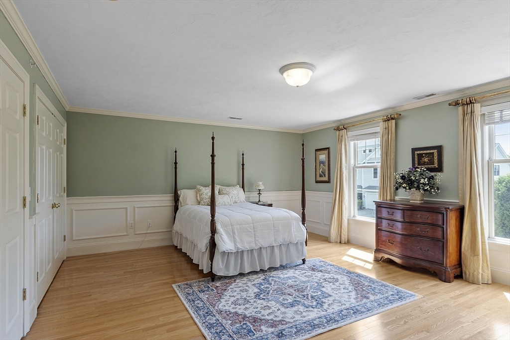 22 Hummock Way, Unit 22 Hudson, MA 01749 - Photo 18 of 23 a bedroom with a large bed and a chandelier