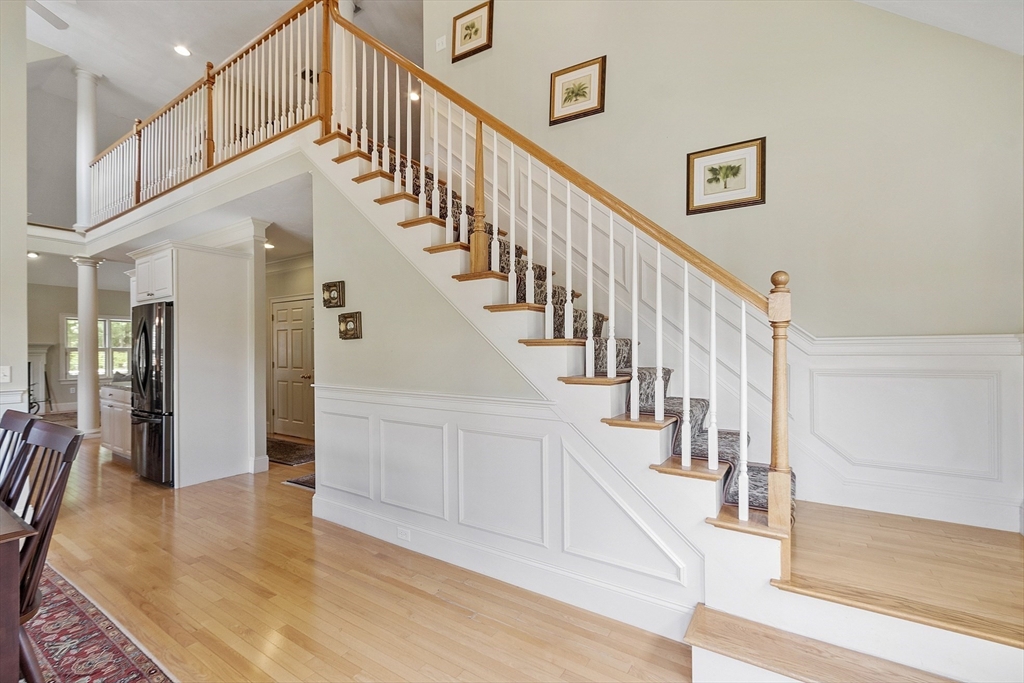 22 Hummock Way, Unit 22 Hudson, MA 01749 - Photo 5 of 23 a view of staircase with lots of frames on wall and wooden floor