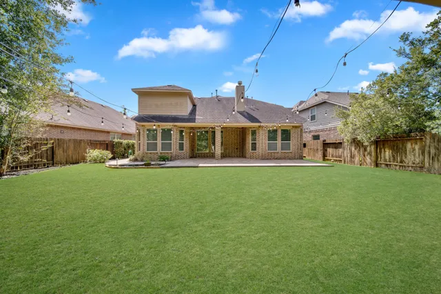 an aerial view of a house with garden space and a car park side of the road
