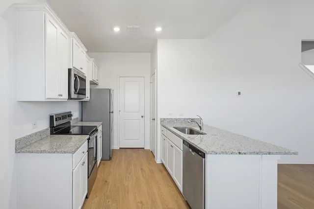 a kitchen that has a sink a stove and a refrigerator