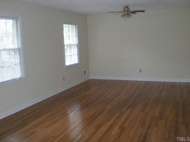 3113 Sherry Drive Raleigh, NC 27604 - Photo 2 of 12 an empty room with wooden floor and windows